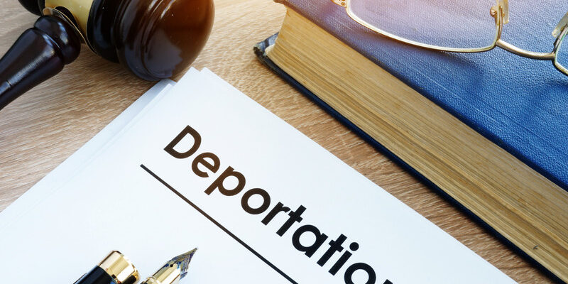 Deportation and other documents on a desk.